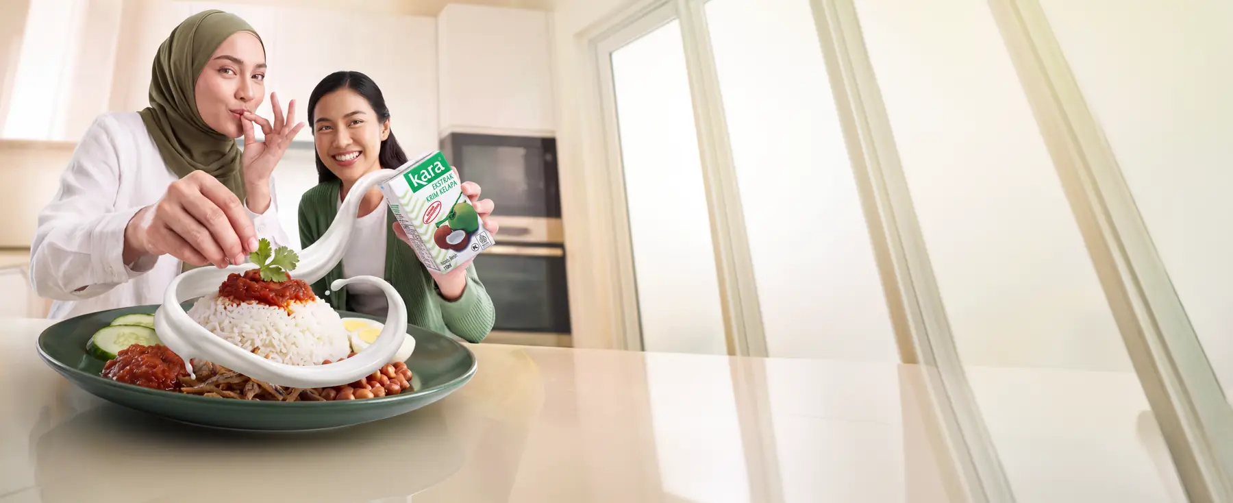Dua wanita di dapur menikmati nasi lemak sambil memegang kotak Kara Ekstrak Krim Kelapa